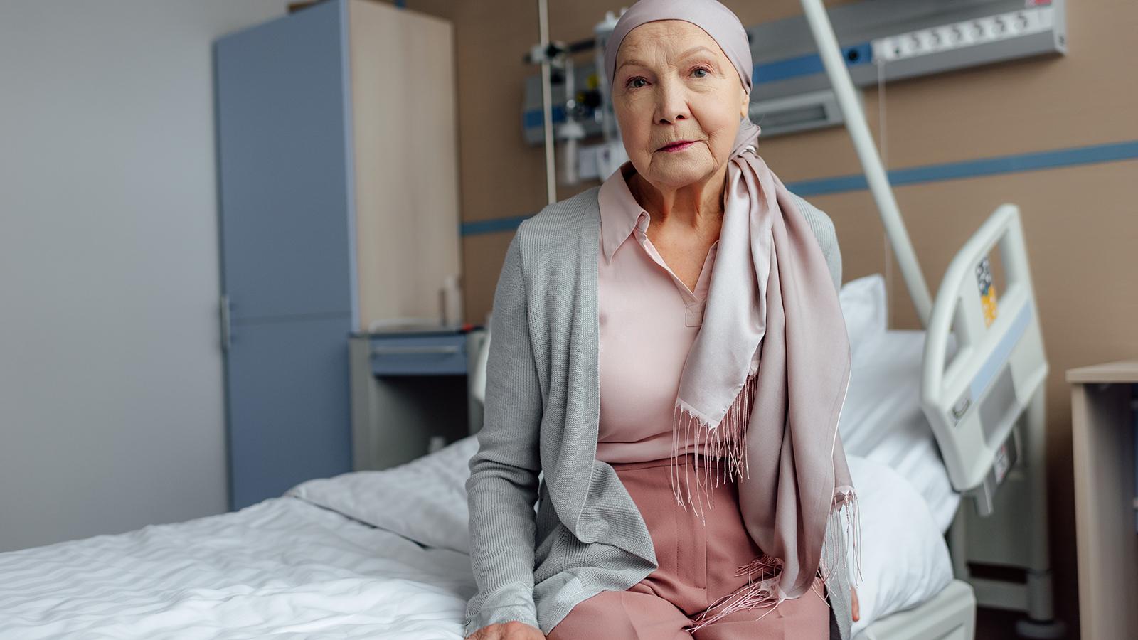 Eine Krebspatientin sitzt auf dem Bett einer Palliativstation im Krankenhaus.